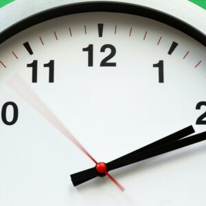 A close-up image of an analog clock face showing time with blurred motion