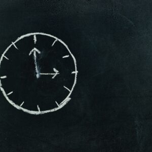 Chalk-drawn clock on a blackboard, symbolizing time and education concepts.